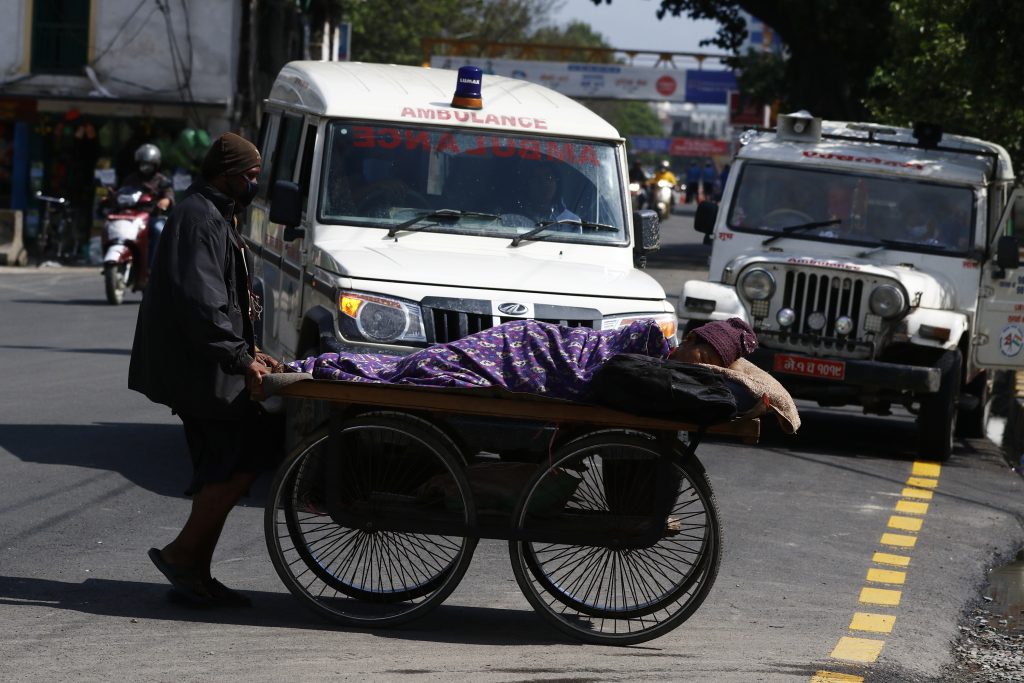 A man takes his wife to Bir Hospital on a push cart for dialysis